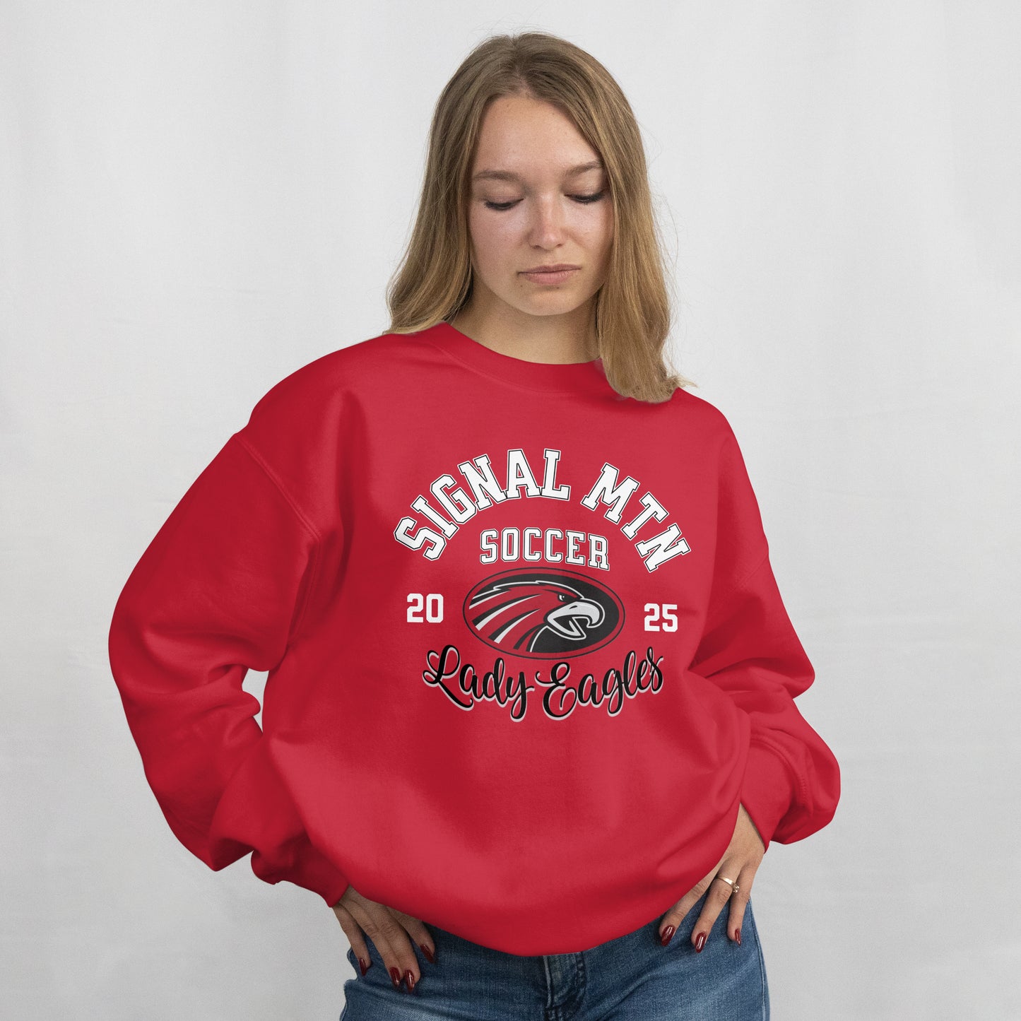 Person wearing a red 'Signal Mountain Soccer' sweatshirt with a logo on a plain background